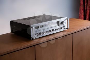 Vintage Stereo Receiver Standing on the Wooden Sideboard, Side View