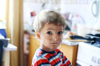 little boy in stripped wear with cute face indoors