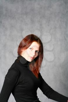This is portrait of a beautiful redhead girl on gray
