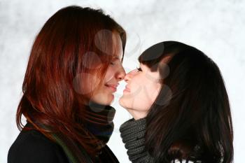 two beautiful redhead and brunette girls with scarf having fun