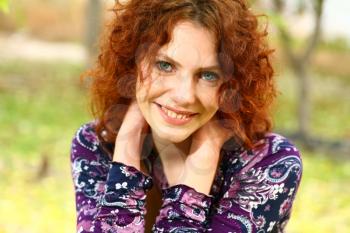 Portrait of a redheaded girl near a tree (autumn colors).