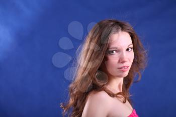 Studio portrait of a beautiful young brunette woman face on blue