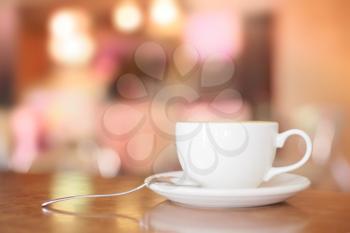 White Coffee Cup on brown wooden table with bokeh