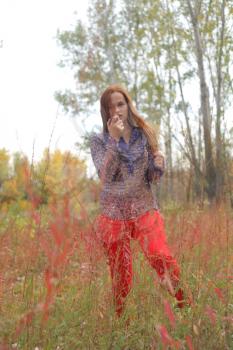 woman in autumn park in red grass, outdoor portrait