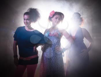 Three glamorous girls having fun at disco in night club