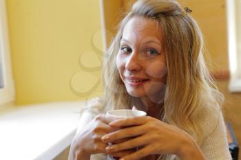 The young beautiful girl with a cup headshot