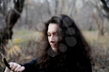 Shot of a gothic woman in a autumn park. Halloween.