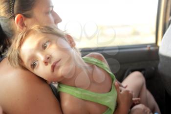 Traveling with a baby. Mother and baby in the back seat of a car on a road trip.