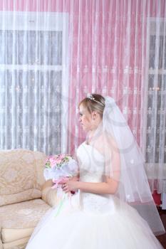 Happy bride with a bouquet of roses. Indoors