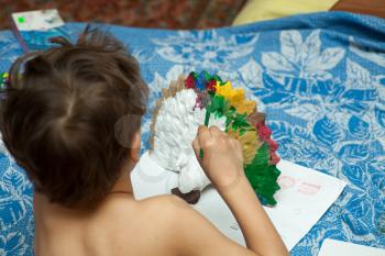 Cute little boy painting with brush