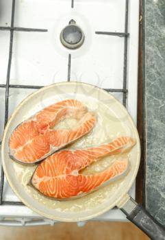 Preparing healthy salmon lunch in a frying pan