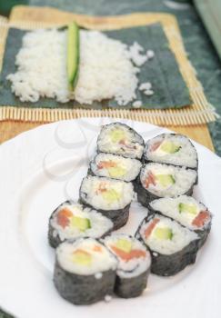 An image of women making california roll close-up