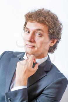 Portrait of handsome man in the black suit. Head and shoulders shot. Hand near head.