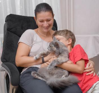 mother and son with cat in the living room having fun