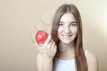 Beautiful blonde woman holding a red apple - health concept. Pretty smile deep blue eyes