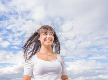 beautiful long hair brunette woman aganst sky summer day portrait