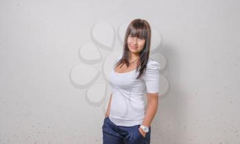 hot young brunette girl in front of white wall horizontal shot