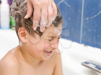 boy in soap bubbles in the bathroom very happy