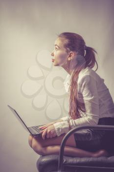 Beautiful young woman working with a laptop in the room toned imade