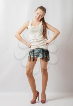 Young sexy woman in denim jeans shorts on white background front view