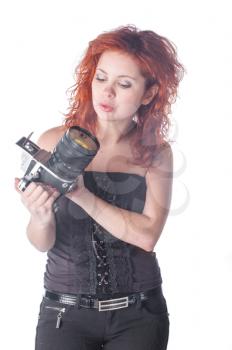 Photo of a beautiful female with red hair holding an old film camera.