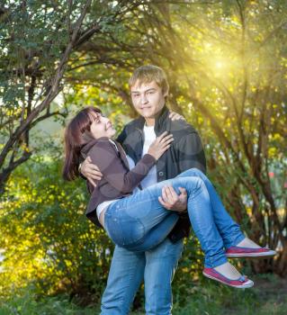 Happy young couple. Holding women on the hands and fav fun a lot of positive emotions