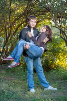 Happy young couple. Holding women on the hands and fav fun a lot of positive emotions