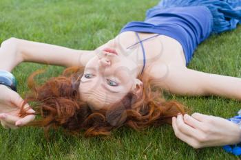 20s redhead women lay in the fresh grass and having summertime fun and enjoyment
