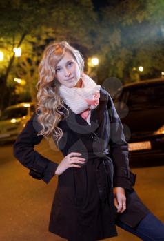 Young blond woman standing on the street at night