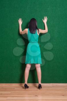 Backview shot of gesturing brunette. Backside image of lady weared green dress