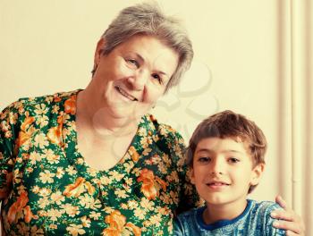 grandma and grandson looking at camera. Indoors image.