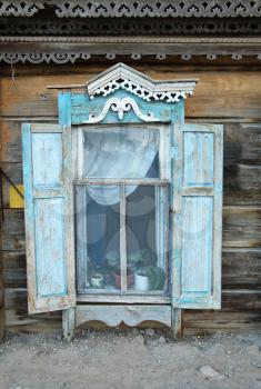 Vintage window of a old wooden house in Russia.