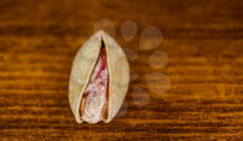 Salted Pistachio in shell on a wooden cutting board macro image with copyspace