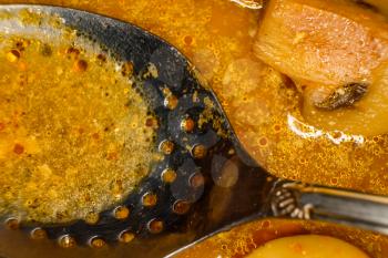 Asian muchroom curry with Sauce and serving spoon with holes, macro image