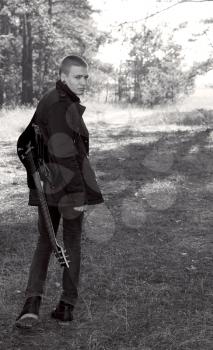 teen musician with a guitar in the autumn forest