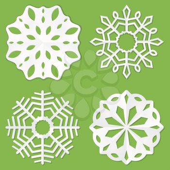 Set of white paper snowflakes on a green background