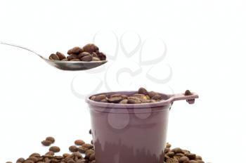 Royalty Free Photo of a Spoon Above a Cup Full of Coffee Beans