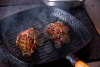 Royalty Free Photo of Beef Steak Grilling in a Cast-Iron Pan