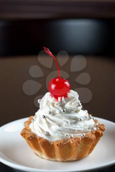 fresh baked cherry cupcake on a dark wooden background