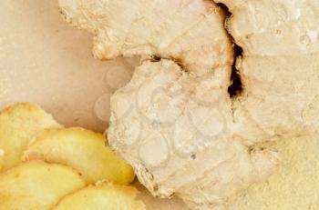 Fresh, dried and powdered ginger at brown background