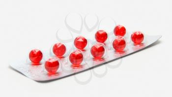 Pack of red pills isolated on white background
