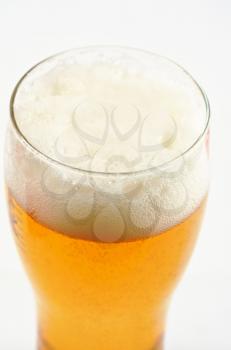 Glass of beer closeup on a white background