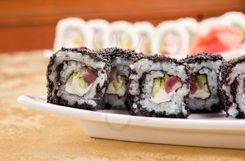 sushi roll with tuna, avacado, sauce and flying fish roe, closeup