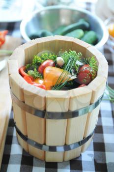 preserved tomatoes, cucumbers, peppers in wooden jar