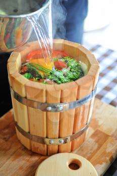 preserved tomatoes, cucumbers, peppers in wooden jar