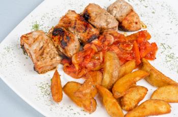Grilled kebab pork meat with roasted potato and vegetables