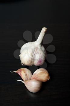 plait of garlic bulbs close-up on black background