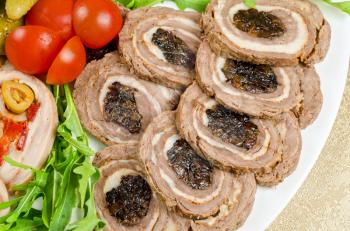 Cutting meat tenderloin with prune with lettuce, tomatoes and Ruccola