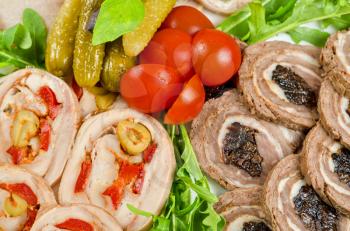 Cutting meat tenderloin with prune with lettuce, tomatoes and Ruccola