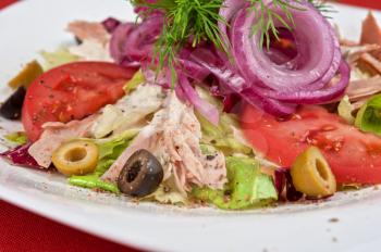 Salad of lettuce, tomato, chicken meat, olive, greens, onion